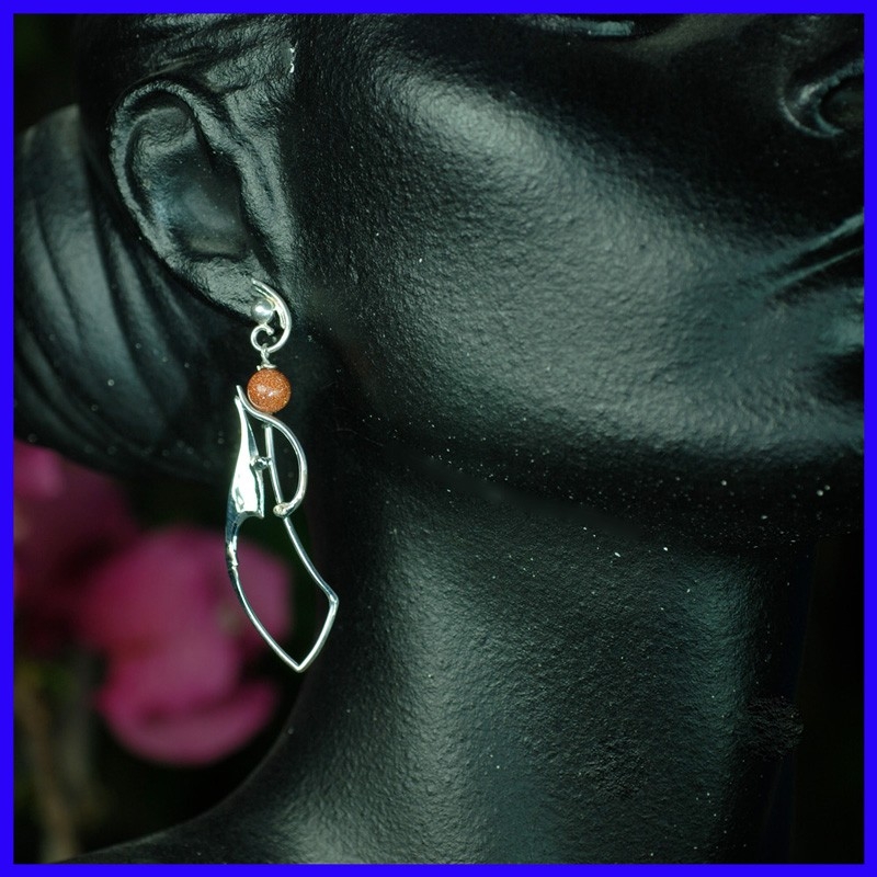 Pair of hanging silver earrings surmounted by sun beads. Handmade jewelry